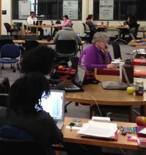 UMD Graduate School students work at various tables in the Writing Center