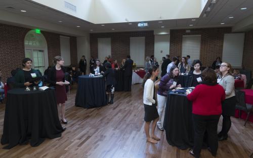 many people standing in room at tables