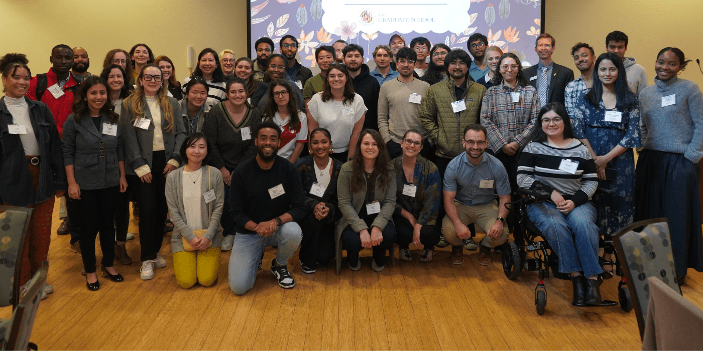 Large group of graduate students smiling at the camera, along with Dean Stephen Roth.