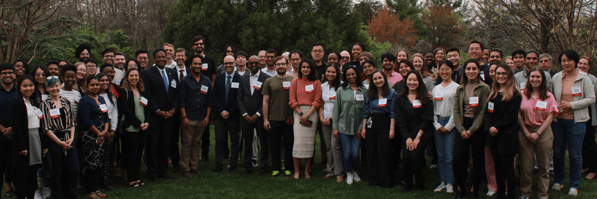 Large group of graduate students smiling at the camera, along with Dean Stephen Roth and President Pines.