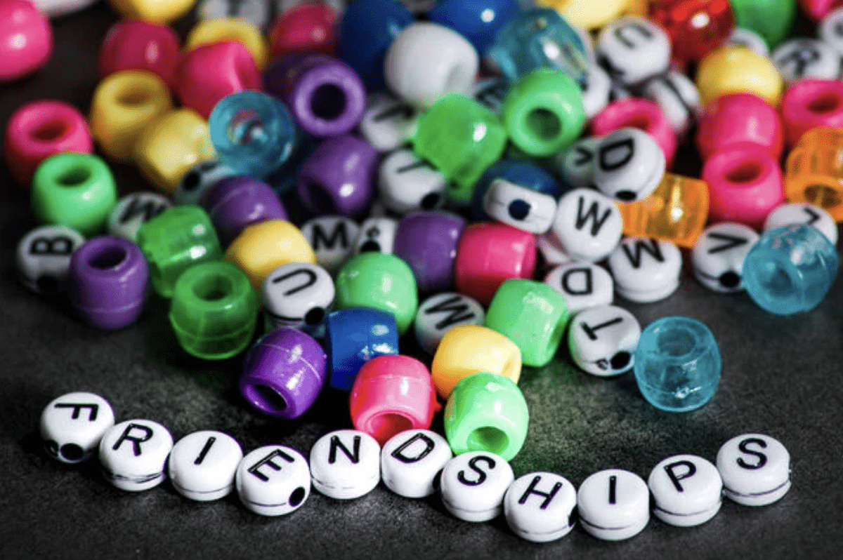 Beads and charms that spell out the word "friendships"